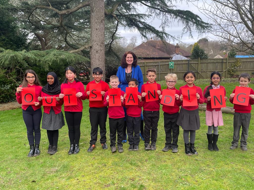 Students holding Ofsted Outstanding sign